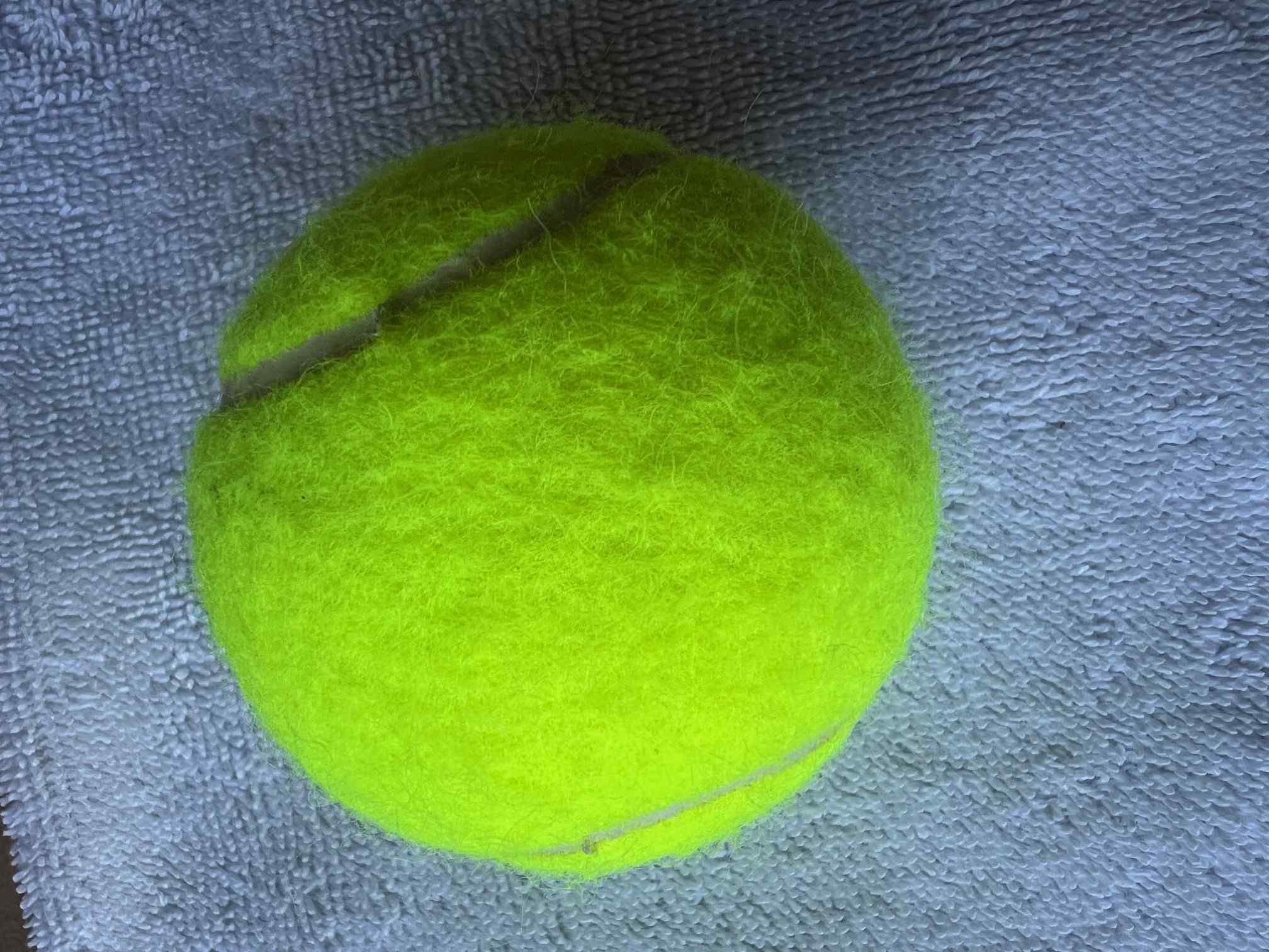 Close-up of a tennis ball showing felt texture and typical surface detail